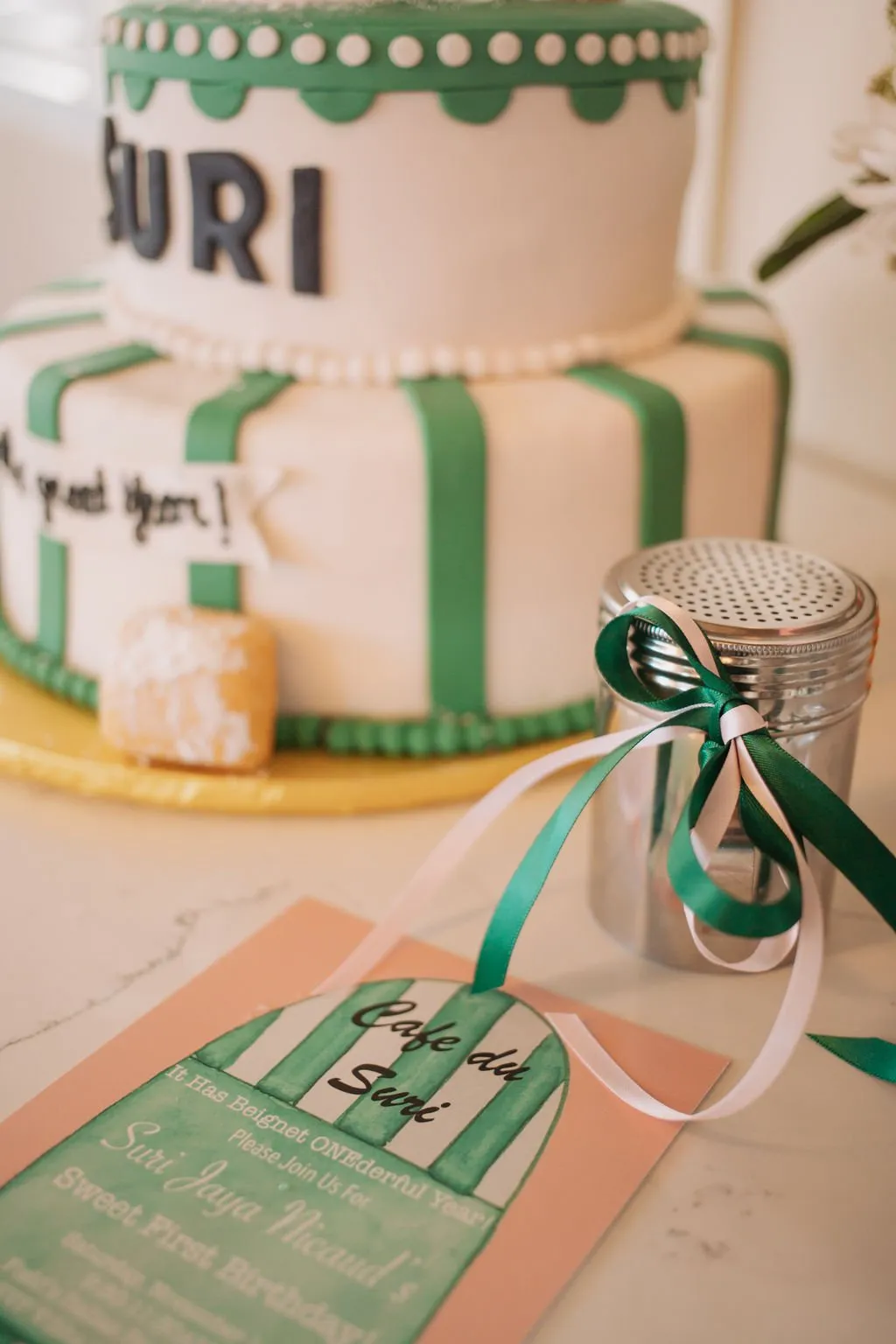 Green-striped Cafe du Suri birthday cake with beignets and invitation