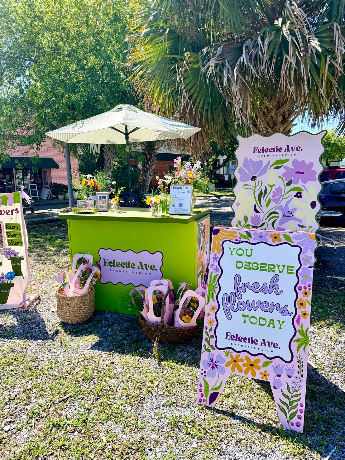 Green flower cart with hand-painted signage and fresh bouquets