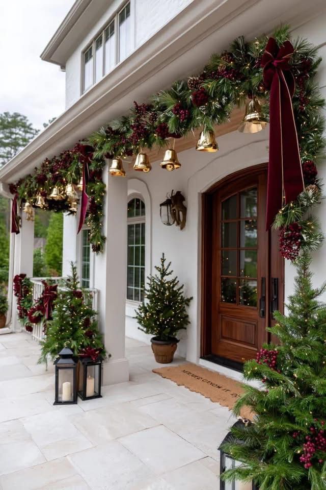 Holiday wreath with layered pink and rust ribbons on a green front door