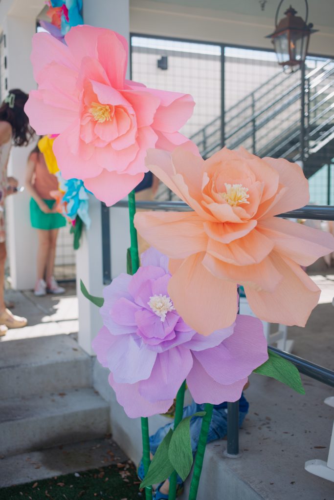 Oversized pastel paper flowers used as an event backdrop